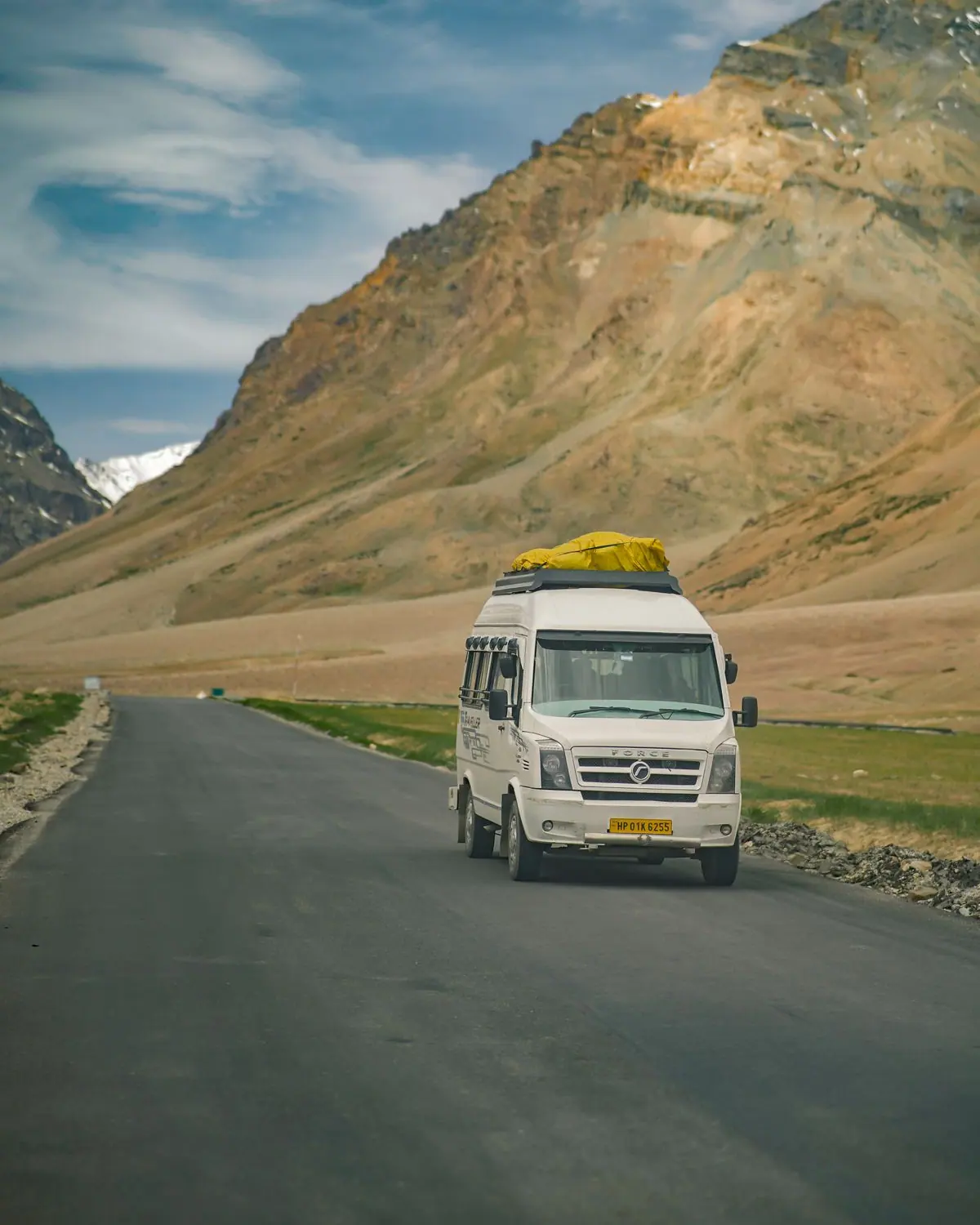 Tempo Traveller on a mountain road during a group tour from Noida
