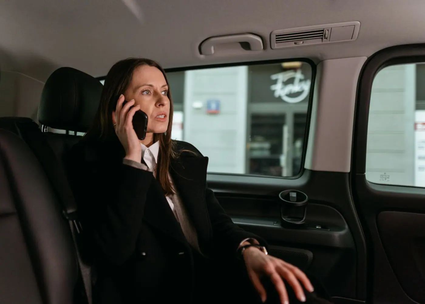 Business traveller on a call in the back seat of a corporate cab in Noida