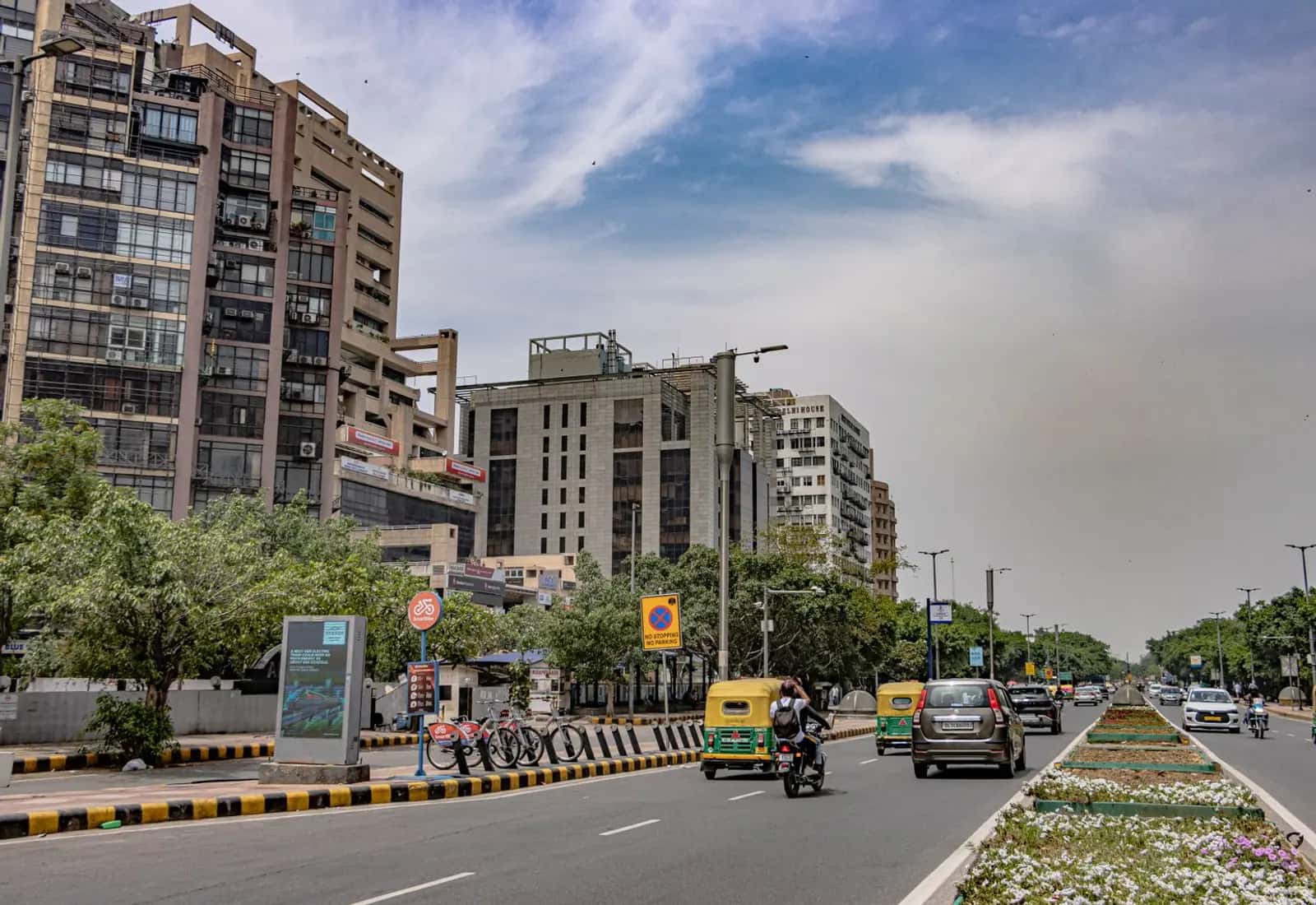 Traffic on a wide NCR arterial road lined with office buildings